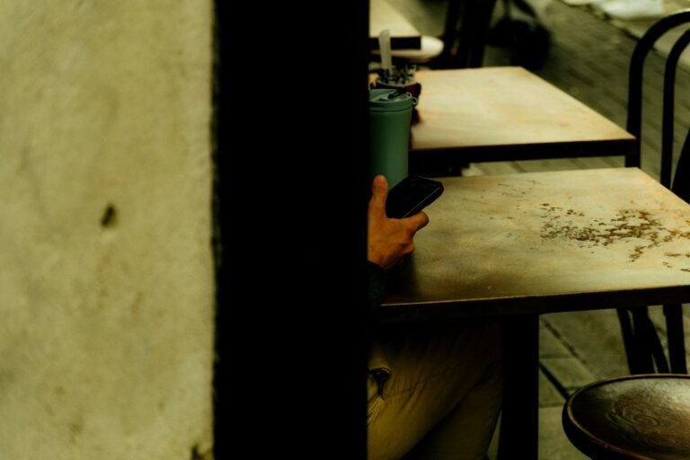 Person holding a phone at a cafe table